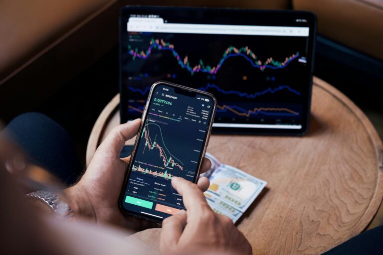 Close-up of a person trading stocks using a smartphone and a tablet. best stock market apps usa