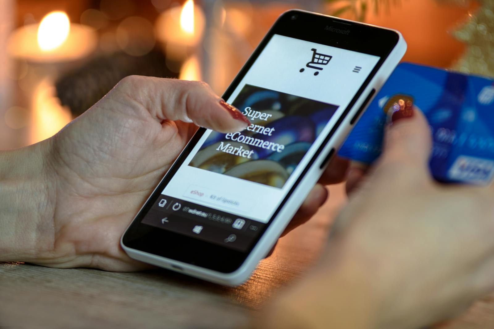 Woman using smartphone for online shopping with credit card in hand, festive background lighting. Business Idea