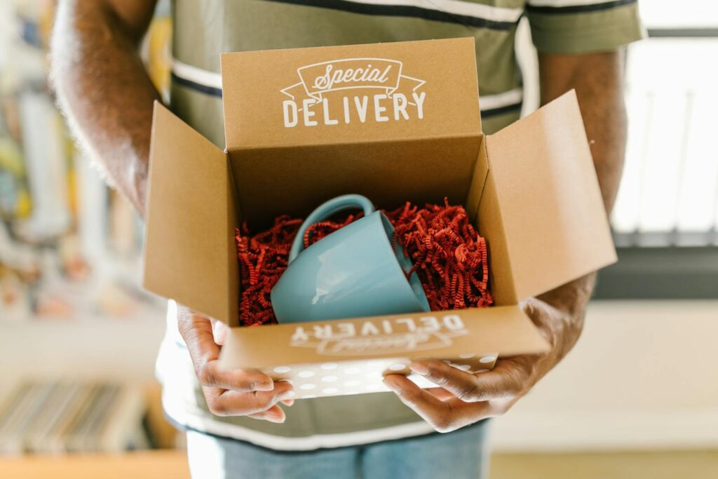 Man holding a box with a special delivery coffee mug inside. 30 Best Business Ideas in USA
