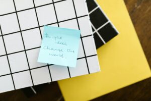 Blue sticky note with motivational quote on grid and solid colored notebooks. 30 Best Business Ideas in USA