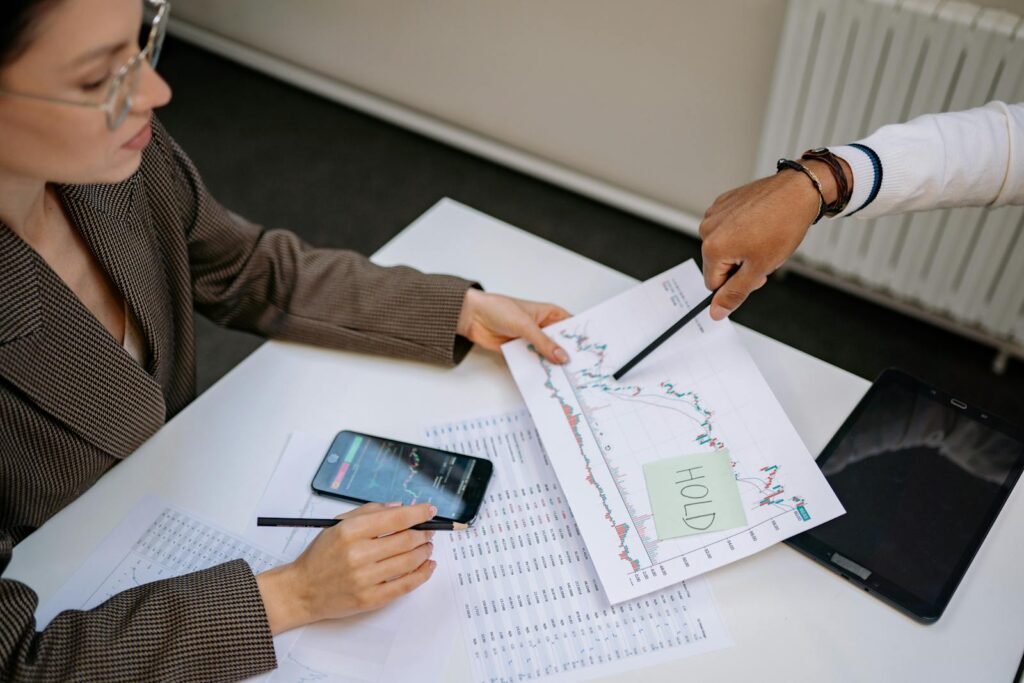 Two professionals analyzing stock market data and graphs at a desk. How to Read Stock Charts Like a Pro