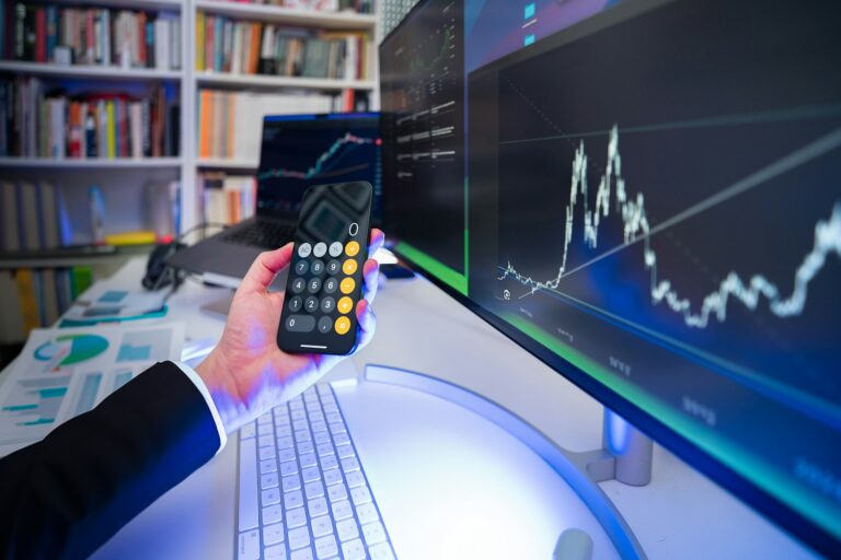 A man holding a remote control in front of a computer,The Ultimate Guide to Invest Like a Billionaire