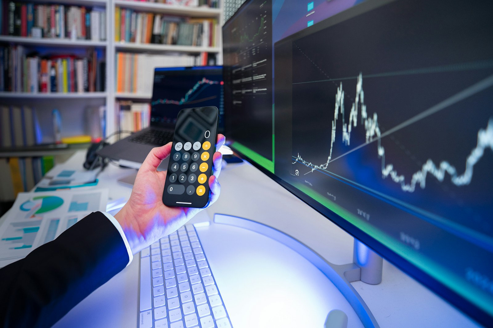 A man holding a remote control in front of a computer,The Ultimate Guide to Invest Like a Billionaire